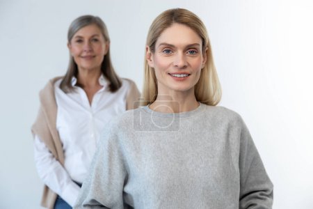 Photo for Confidence. Blonde long-haired woman standing, her mom standing behind - Royalty Free Image