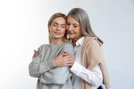 Foto de Familia. Madre e hija abrazándose y luciendo pacíficas - Imagen libre de derechos