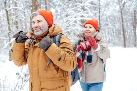Photo for Winter walk. Mature couple in a winter forest feeling happy - Royalty Free Image