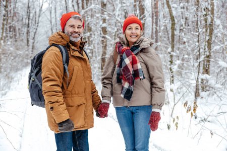 Photo for Winter. Mature couple in a snowy forest feeling excited - Royalty Free Image