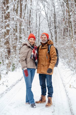 Photo for Happy couple. Happy mature couple in a snowy forest feeling wonderful - Royalty Free Image