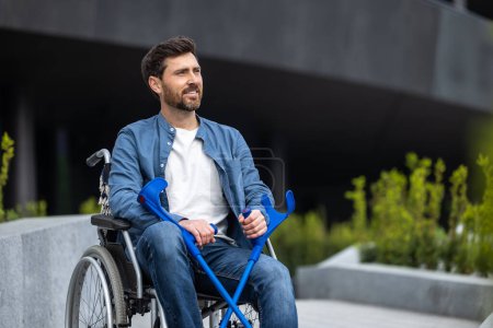 Téléchargez les photos : Réadaptation. Jeune homme handicapé en fauteuil roulant - en image libre de droit