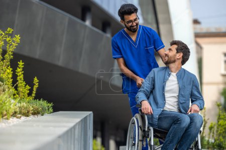 Foto de Camina en silla de ruedas. Enfermera que lleva una silla de ruedas con un paciente masculino - Imagen libre de derechos