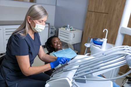Téléchargez les photos : Dentiste avec patiente en clinique dentaire - en image libre de droit