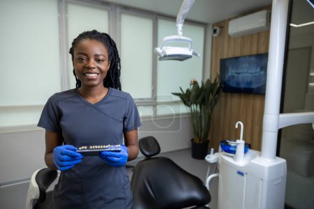 Téléchargez les photos : Médecin dentiste femme tenant des dents dentaires nuance guide graphique - en image libre de droit