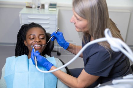 Téléchargez les photos : Femme dentiste traitant les dents des patients en clinique médicale - en image libre de droit