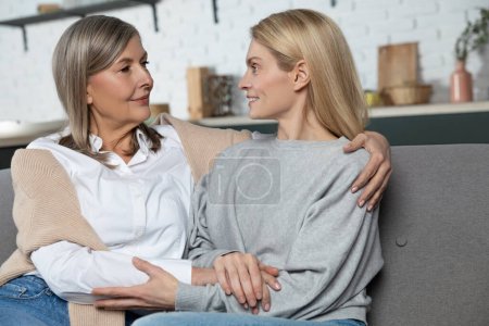 Téléchargez les photos : Femme mûre avec sa fille adulte jouissant d'une communication chaleureuse à la maison - en image libre de droit
