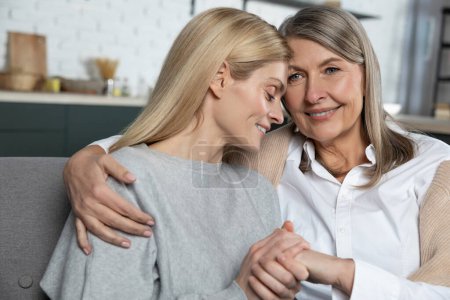 Photo for Delighted mature woman with her adult daughter enjoying warm communication at home - Royalty Free Image