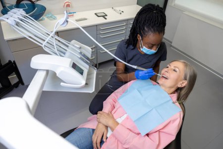Téléchargez les photos : Patiente recevant un traitement dentaire dans un centre médical - en image libre de droit