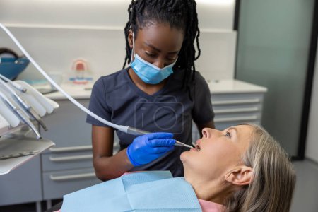 Téléchargez les photos : Femme ayant des dents examinées à la clinique des dentistes - en image libre de droit