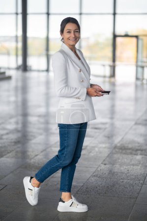 Foto de Mujer de negocios. Mujer bonita con chaqueta blanca en el edificio de oficinas - Imagen libre de derechos
