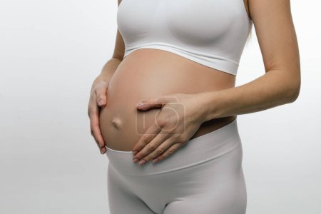 Téléchargez les photos : Troisième trimestre. Photo rapprochée d'une femme enceinte au troisième trimestre - en image libre de droit