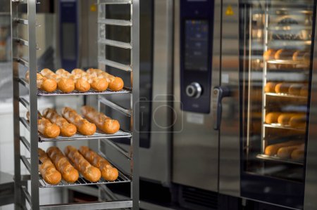 Photo for Multiple trays of baguettes fresh out of oven at commercial bakery - Royalty Free Image