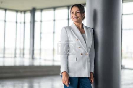 Photo for Woman at pillar. Pretty smiling business woman standing near the pillar - Royalty Free Image