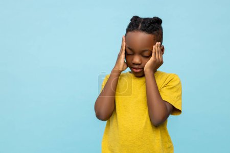 Photo for Sick dark- skinned little boy suffering headache isolated over blue background - Royalty Free Image