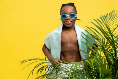 Foto de Hora de nadar. Lindo chico afroamericano en gafas de natación y con toalla en el hombro - Imagen libre de derechos