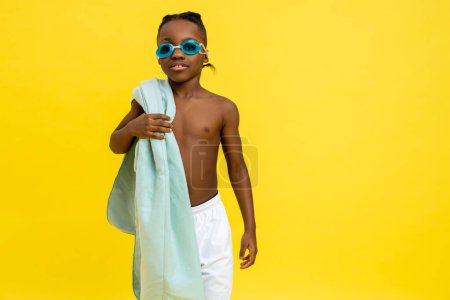 Foto de Hora de nadar. Lindo chico afroamericano en gafas de natación y con toalla en el hombro - Imagen libre de derechos