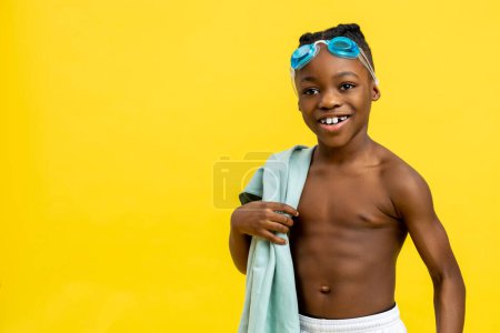 Foto de Hora de nadar. Niño sonriente con gafas de baño en la frente y toalla en las manos - Imagen libre de derechos