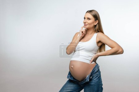 Téléchargez les photos : Grossesse. Jeune femme enceinte aux cheveux longs au troisième trimestre - en image libre de droit