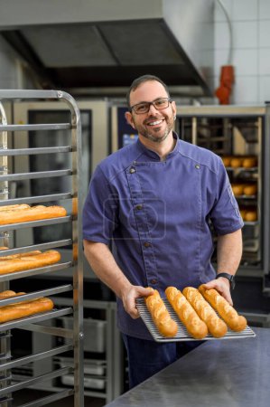 Foto de Hombre panadero hornear y vender sabrosos panes en panadería - Imagen libre de derechos