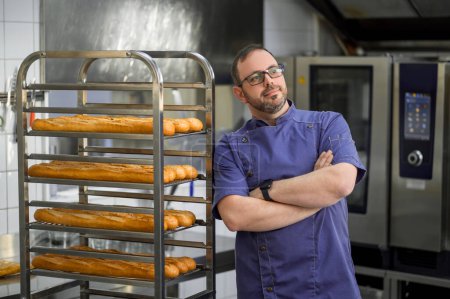 Téléchargez les photos : Boulanger professionnel à la boulangerie avec baguette de pain au boulangerie - en image libre de droit