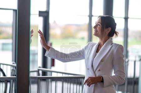 Photo for In the business center. Pretty smiling business woman standing near the banister - Royalty Free Image
