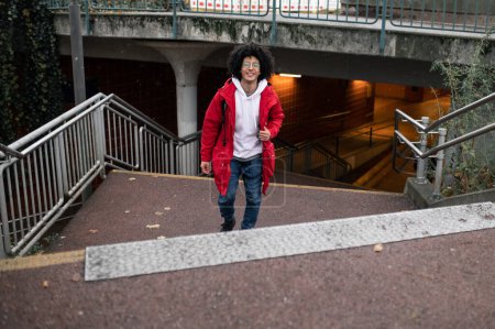 Téléchargez les photos : À la gare. Jeune homme montant sur les marches de la gare - en image libre de droit