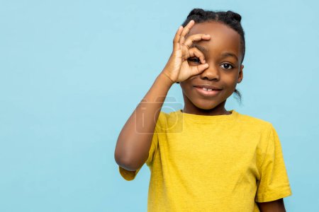 Photo for Smiling satisfied dark- skinned little boy looking throwing okay sign isolated over blue background - Royalty Free Image