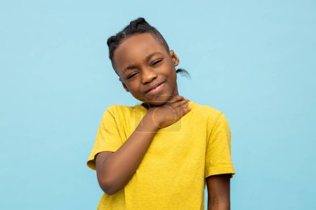 Téléchargez les photos : Malade afro-américain petit garçon souffrant mal de gorge isolé sur fond bleu - en image libre de droit