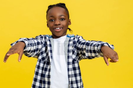 Téléchargez les photos : Joyeux gamin. Souriant garçon afro-américain en chemise à carreaux regardant heureux - en image libre de droit