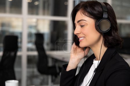 Téléchargez les photos : Jeune brunette sympathique opérateur femme agent avec écouteurs travaillant dans le centre d'appel - en image libre de droit