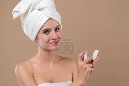 Téléchargez les photos : Femme faisant choyer soin du visage routine isolée sur fond brun - en image libre de droit