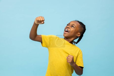 Téléchargez les photos : Un garçon excité. Africain américain garçon en chemise jaune regardant excité - en image libre de droit