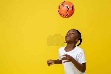 Photo for Happy little multiracial boy playing with ball copy space for advertisement isolated over yellow background, copy space - Royalty Free Image