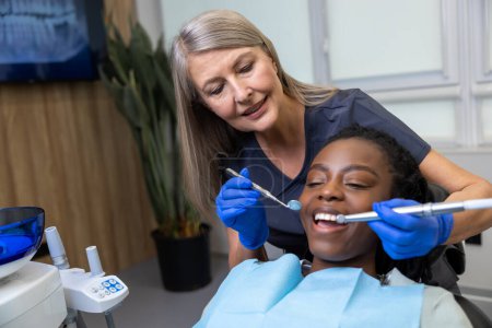 Photo for Tooth care. Young woman having a session of tooth treatment at the dentists - Royalty Free Image