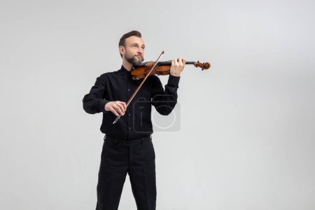 Photo for Elegant musician man violinist playing on concert isolated over light gray background - Royalty Free Image