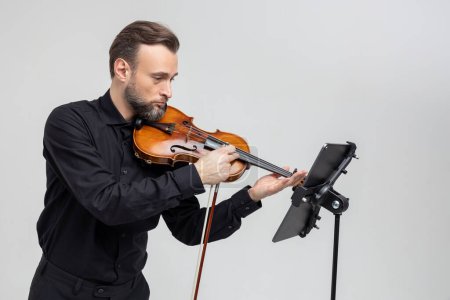 Foto de Hombre guapo sosteniendo un violín en sus manos tocando música clásica aislada sobre fondo blanco - Imagen libre de derechos