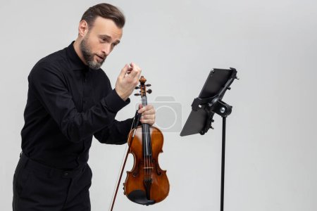 Foto de Músico profesional tocando violín realizando concierto de pie aislado sobre fondo gris claro - Imagen libre de derechos