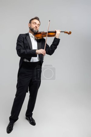 Photo for Bearded violinist playing classical music at concert isolated over light gray background, copy space - Royalty Free Image
