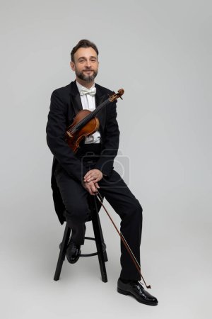 Photo for Bearded fiddler with violin instrument isolated over light gray background - Royalty Free Image