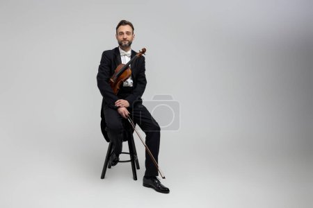 Photo for Bearded violinist with instrument classical music at concert isolated over light gray background, copy space - Royalty Free Image