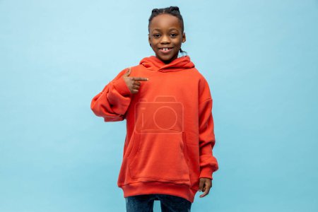 Foto de Niño afroamericano. Lindo afroamericano chico en naranja sudadera con capucha - Imagen libre de derechos
