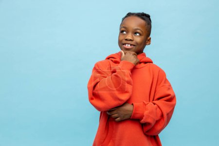 Foto de African american boy. Cute african american boy in orange hoodie - Imagen libre de derechos