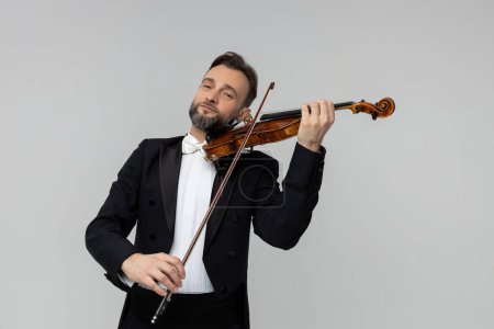 Photo for Handsome man artist playing violin isolated over light gray background, copy space - Royalty Free Image