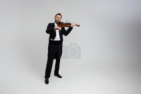Photo for Man classic violinist at musical elegant performance isolated over light gray background, copy space - Royalty Free Image