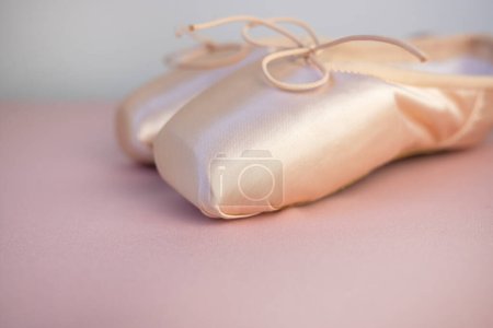 Photo for New pink pointe shoes for ballet on a pink background. Place for text, close-up, side view. - Royalty Free Image