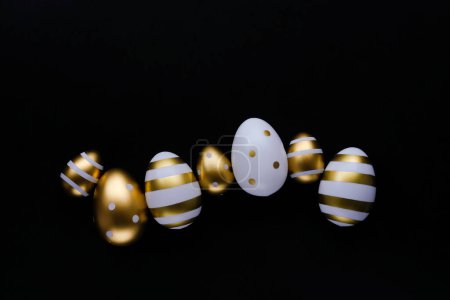 Foto de Banner de Pascua. Huevos dorados en fila sobre un fondo negro. Concepto mínimo. Colocación plana, espacio para texto. - Imagen libre de derechos