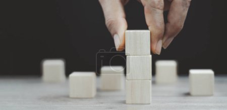 Photo for Hand arranging three wood cube stacking. Business concept growth success,hand stack woods block step on table. business development concept.copy space. - Royalty Free Image