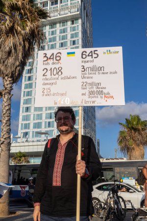 Foto de Tel Aviv, Israel - 20 de marzo de 2022, Protesta contra la agresión rusa en Ucrania. Un hombre sostiene un cartel con estadísticas del comienzo de la guerra en Ucrania - Imagen libre de derechos