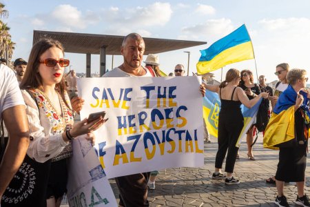 Téléchargez les photos : Tel Aviv, Israël - 20 mars 2022, Manifestation contre l'agression russe en Ukraine. Un homme tient une affiche avec l'inscription Save the heroes of Azovstal - en image libre de droit